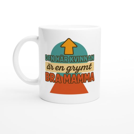 Vit mugg med färgglad text “Den här kvinnan är en grymt bra mamma” och pil uppåt – rolig present med tryck till mamma
