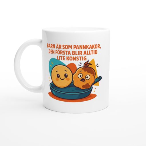 Vit mugg med tecknade pannkakor och texten “Barn är som pannkakor, den första blir alltid lite konstig” – rolig present med tryck till föräldrar