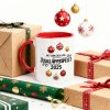 Vit kaffemugg med röd insida och handtag, tryckt med texten "Jag vann den här i Julklappsspelet 2025" och hängande julkulor.